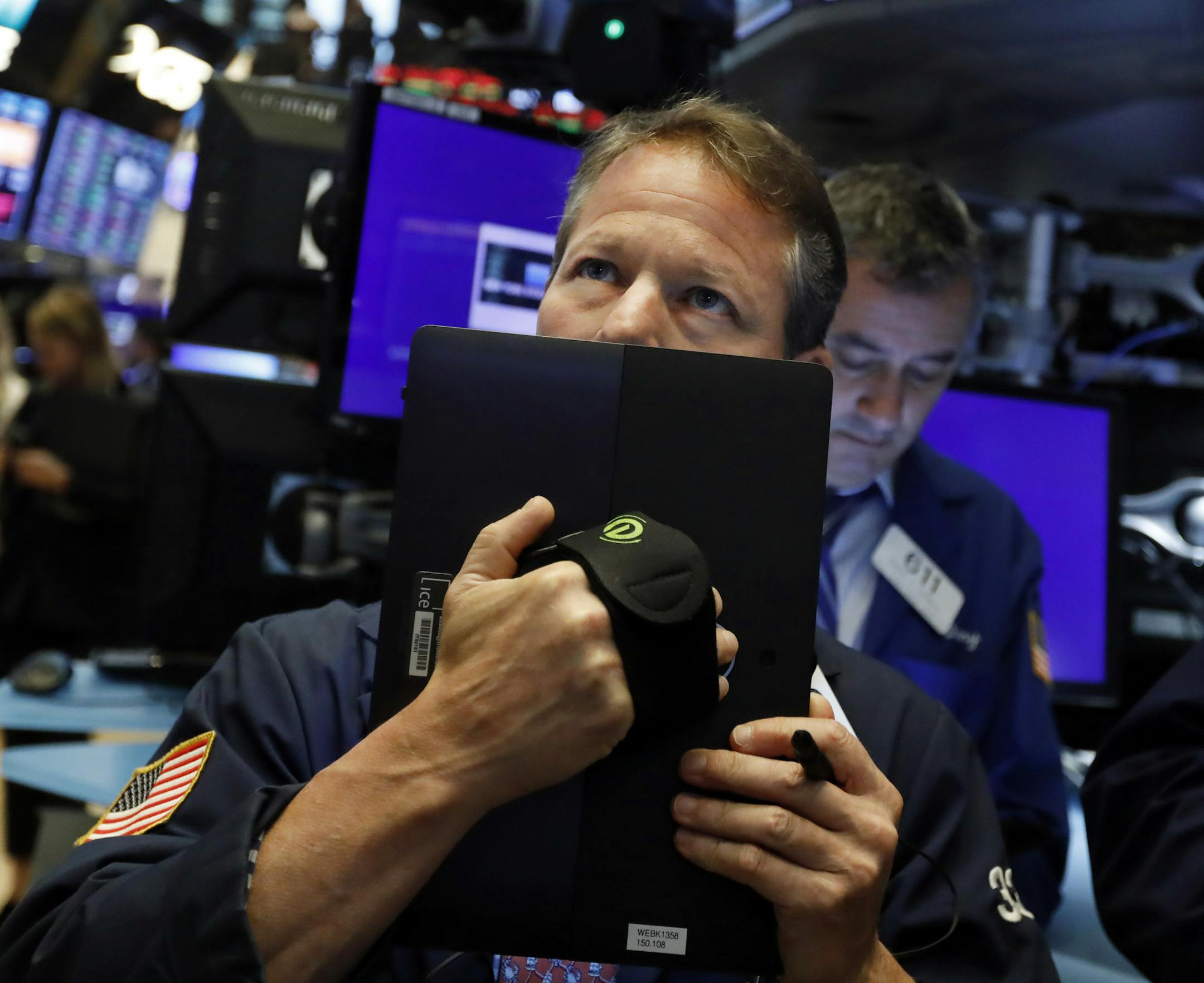 FILE - In this May 17, 2019, file photo trader Robert Charmak works on the floor of the New York Stock Exchange. An unexpected escalation in the trade war between the U.S. and China jolted investors into a defensive position in May. (AP Photo/Richard Drew, File)