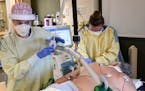M Health Fairview respiratory therapist Kayla Rabideaux and critical care nurse Jessie Master, left, worked with an intubated COVID-19 patient after t