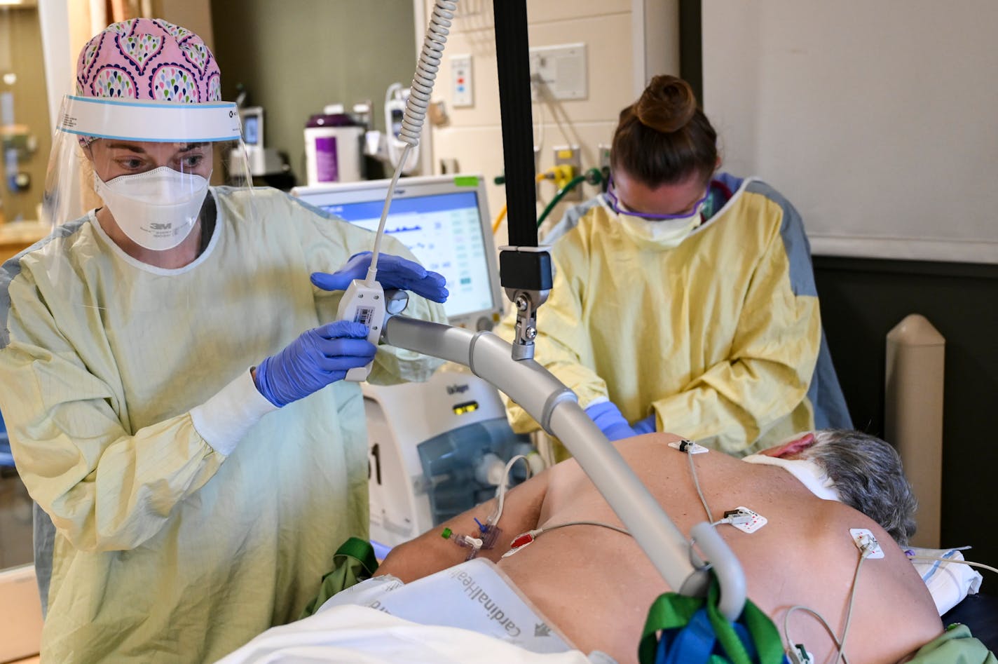 M Health Fairview respiratory therapist Kayla Rabideaux and critical care nurse Jessie Master, left, worked with an intubated COVID-19 patient after they turned their head Thursday afternoon in the ICU. ] AARON LAVINSKY • aaron.lavinsky@startribune.com