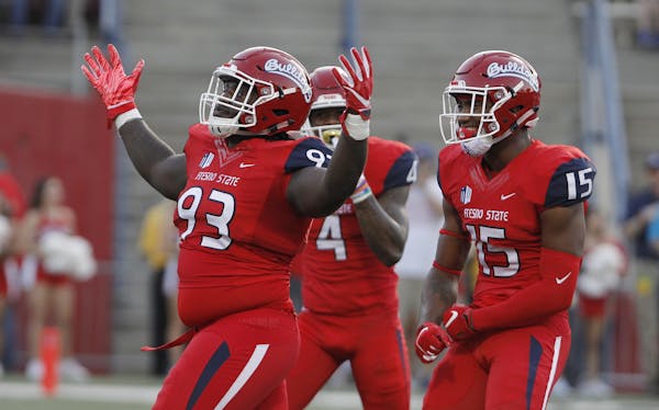 From left to right, Fresno State's Jasad Haynes, Mike Bell and Aaron Mosby celebrate a fumble against Idaho during the first half of an NCAA college f