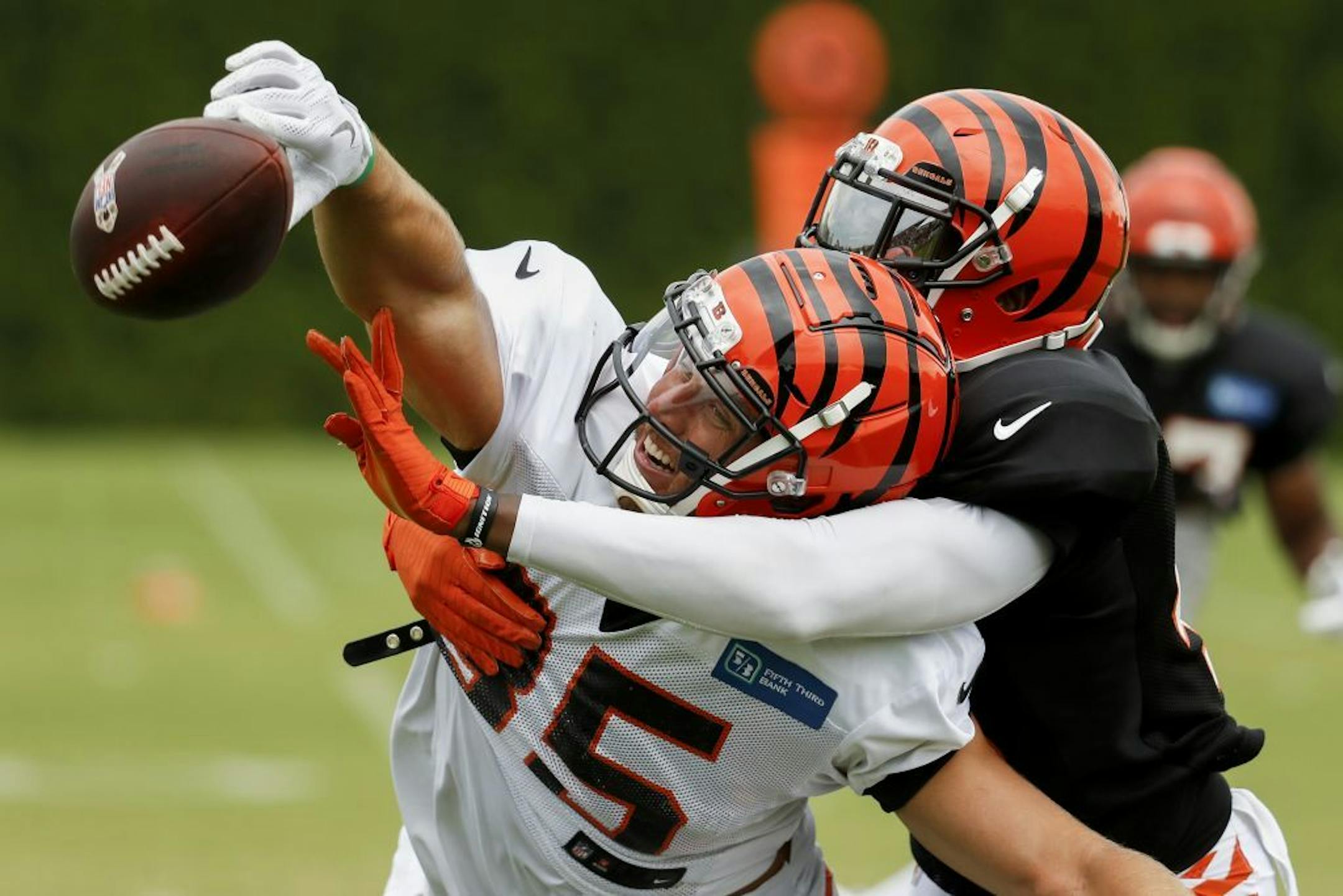 Cincinnati Bengals tight end Tyler Eifert, left, reaches for a pass against safety George Iloka, right, on a play during a training camp practice.