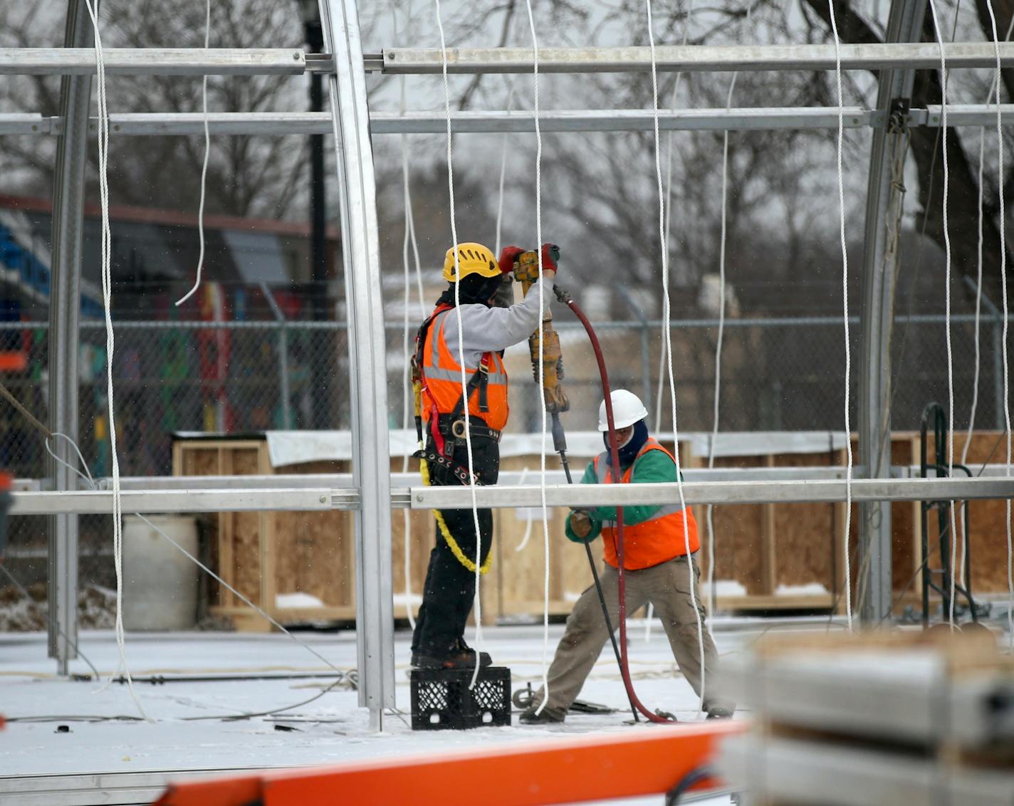 Construction workers erect the metal frame for housing at the site of the new navigation center that will replace the Hiawatha homeless encampment.