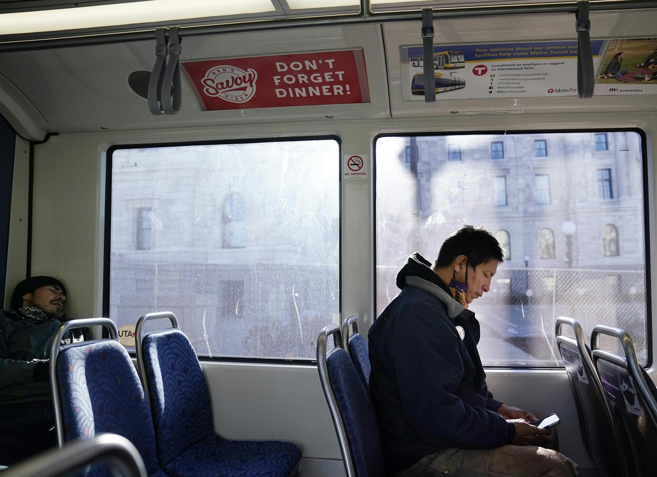 Allen Touche, 48, right, rides the light rail through St. Paul recently, on his way to Minneapolis where weekly on Saturdays he helps to feed homeless Natives and others. Touche himself has battled homelessness and this past summer slept in a tent on a site in Minneapolis know as the Wall of Forgetten Natives.  While still homeless, Touche succeeded in getting a union job working construction on an apartment complex across from the Wall called Mino-bimaadiziwin, in Ojibwe for "the good life" —a low-rent complex targeted specifically to Native Americans and Touche will move in to his own place there come the beginning of 2020. "I put my blood, sweat and tears into this place," he said during a recent visit to the complex.  "My own physical labor built this building." ]