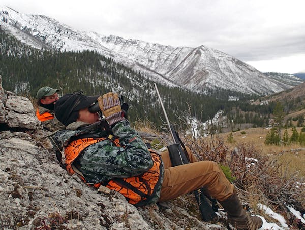 Guide Josh Carlbom of Sun Canyon Lodge glasses for elk on a distant mountainside while hunter Peter Stanford of Milwaukee looks on. The two were in th