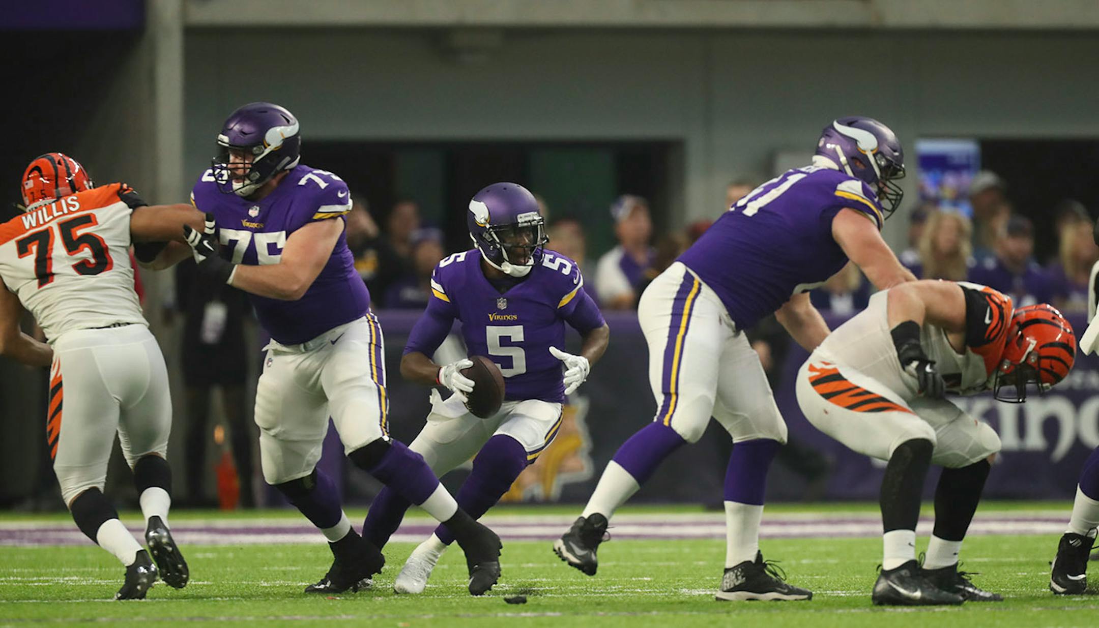 Minnesota Vikings quarterback Teddy Bridgewater (5) looked for a receiver before throwing his first pass - an interception - moments after returning to playing after a knee injury more than a year ago.