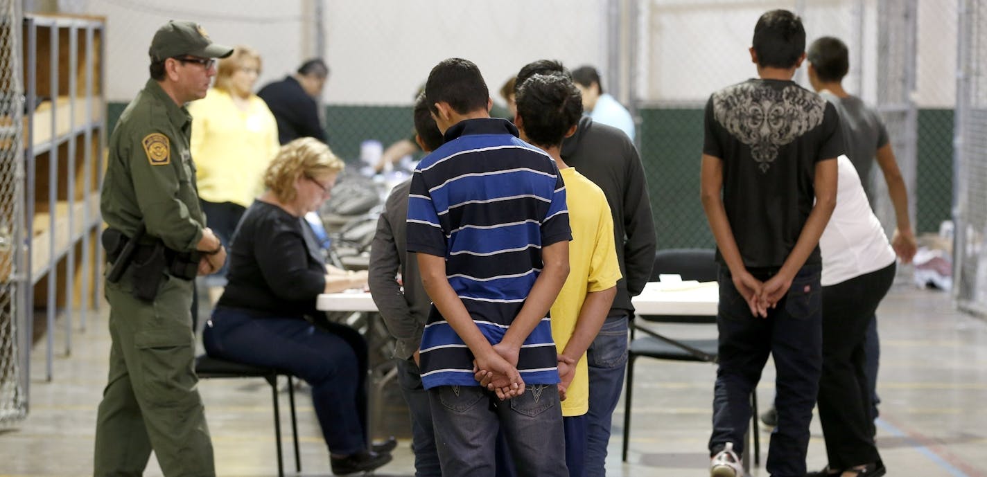 FILE - In this June 18, 2014, file photo, boys wait in line to make a phone call as they are joined by hundreds of mostly Central American immigrant children that are being processed and held at the U.S. Customs and Border Protection Nogales Placement Center in Nogales, Ariz. The Associated Press has learned that a Senate subcommittee has found that the government risks placing migrant children in the custody of human traffickers because federal agencies have delayed crucial reforms needed to ke