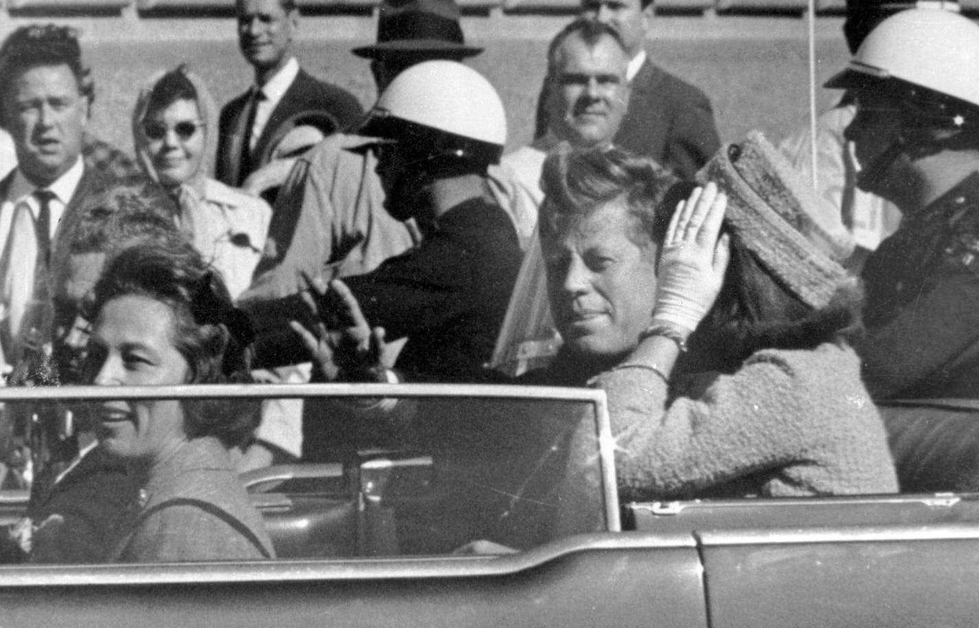 FILE - In this Nov. 22, 1963 file photo, President John F. Kennedy waves from his car in a motorcade in Dallas. Riding with Kennedy are First Lady Jacqueline Kennedy, right, Nellie Connally, second from left, and her husband, Texas Gov. John Connally, far left.