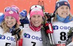 Marit Bjoergen of Norway, center, winner of a cross-country ski, women's World Cup 30k Mass Start event, poses on the podium with second placed United