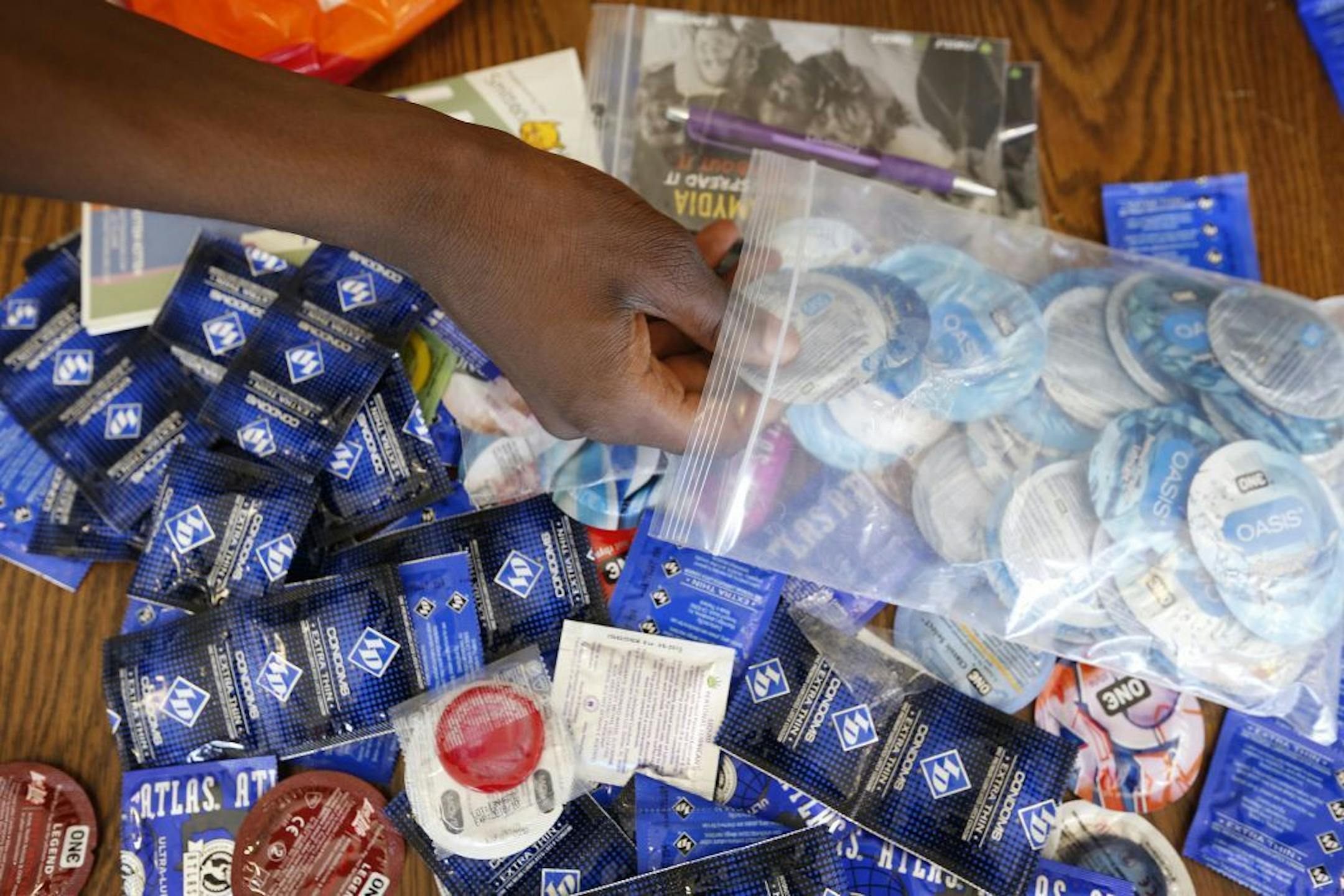 Teens put condoms and sexual lubricant into safe sex kits.