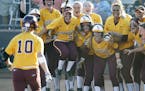 Jubilant Gophers players waited to greet Paige Palkovich (10) after her walk-off grand slam beat Arizona and kept the Gophers alive in the NCAA softba