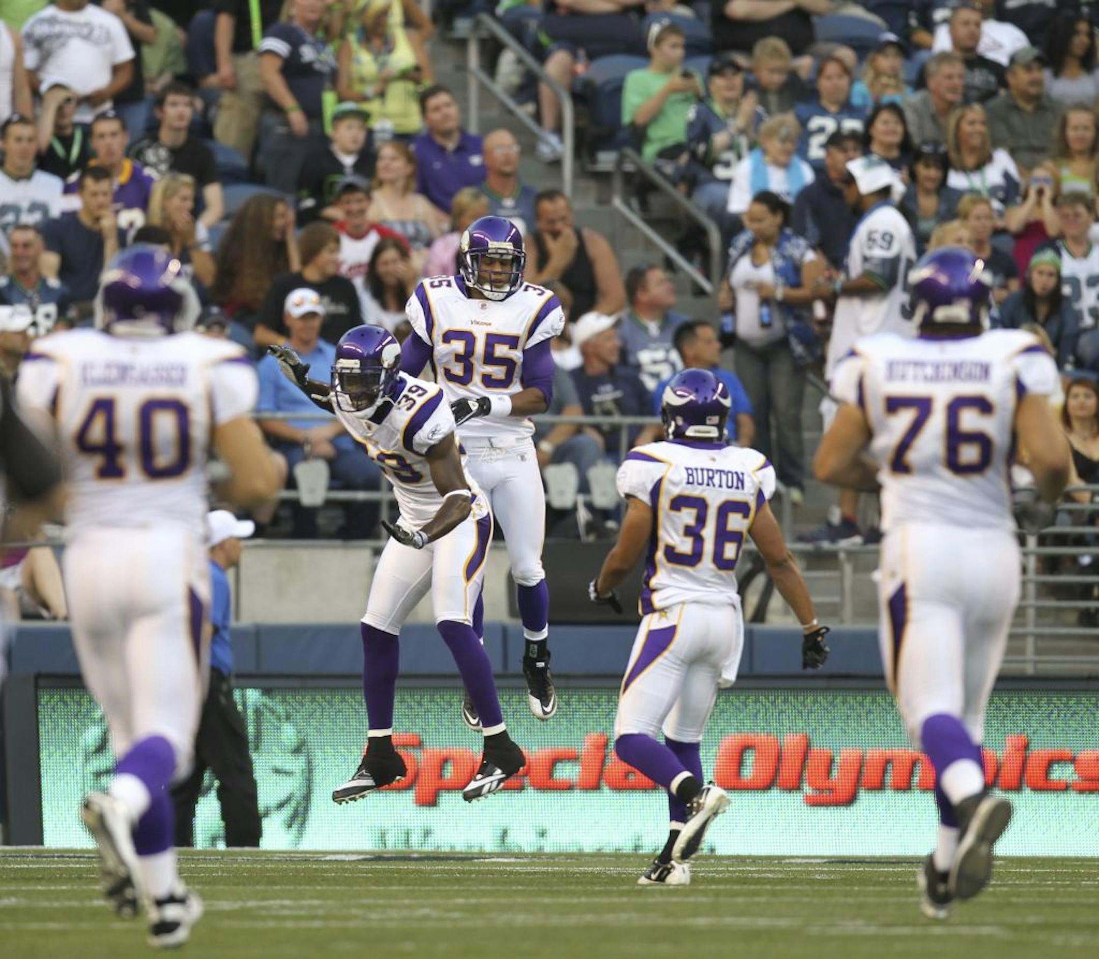 Vikings cornerback' Marcus Sherels (35) celebrated with Husain Abdullah (39) and other teammates after returning an interception 64 yards for a touchdown against Seattle on Saturday.