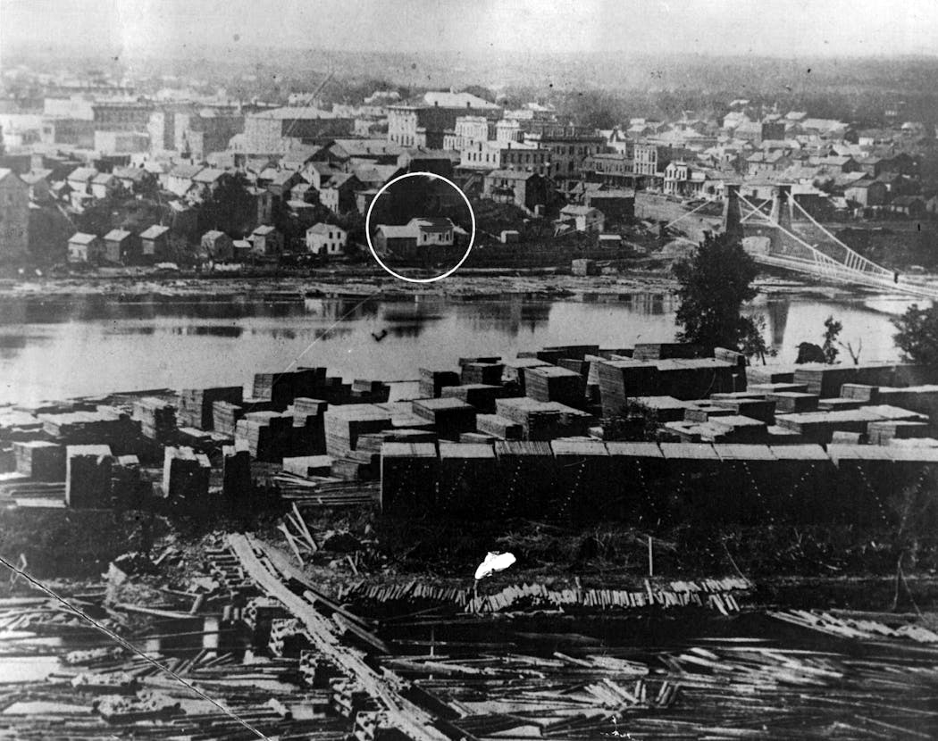 This 19th Century photo of downtown Minneapolis shows the Stevens House in its original location alongside the Mississippi River.