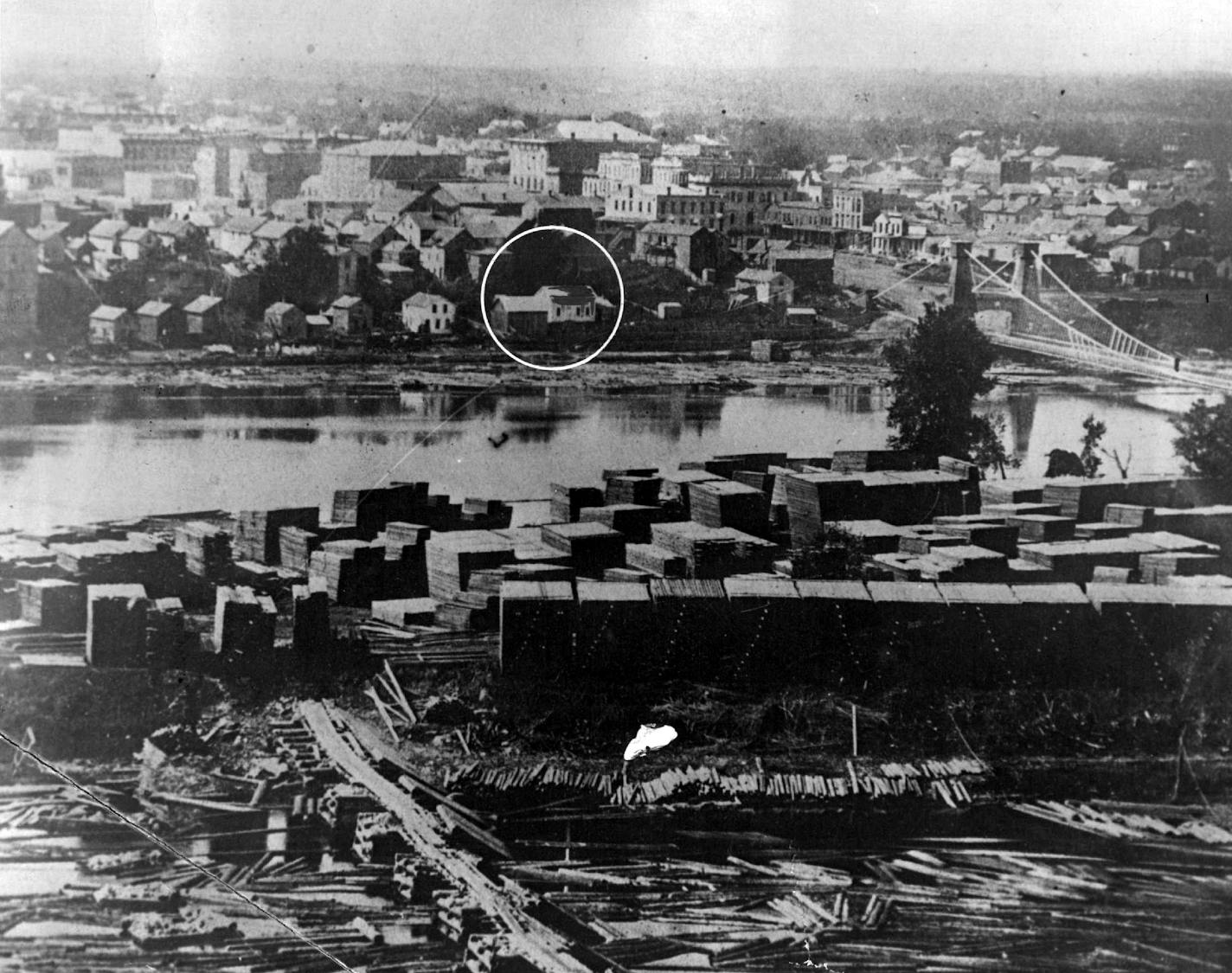 May 1, 1932 The John H. Stevens House first home to be erected in Minneapolis, stood on the west bank of the river just below the first suspension bridge on Hennepin avenue. Just beyond the Stevens house can be see the Pence opera house and the Bridge Square business district, which constituted downtown Minneapolis in 1864.  Minneapolis Journal Library