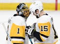 Pittsburgh Penguins goaltender Casey DeSmith (1) and teammate Riley Sheahan (15) celebrate the team's 3-2 win against the Minnesota Wild in an NHL hoc