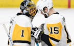 Pittsburgh Penguins goaltender Casey DeSmith (1) and teammate Riley Sheahan (15) celebrate the team's 3-2 win against the Minnesota Wild in an NHL hoc