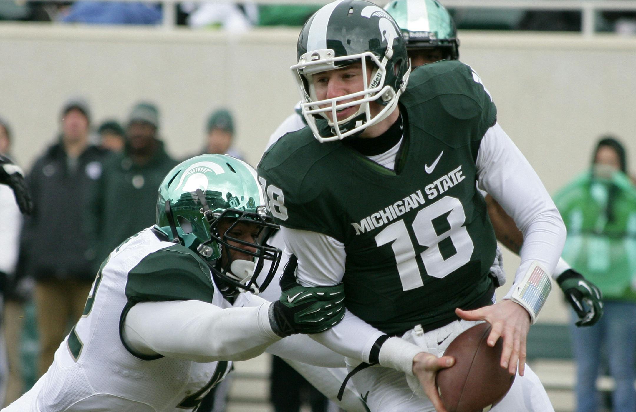 Michigan State Green team quarterback Connor Cook (18) is sacked by White team's Denzel Drone during an NCAA college football scrimmage on Saturday, April 20, 2013, in East Lansing, Mich. The White team won 24-17. (AP Photo/Al Goldis) ORG XMIT: MIAG102