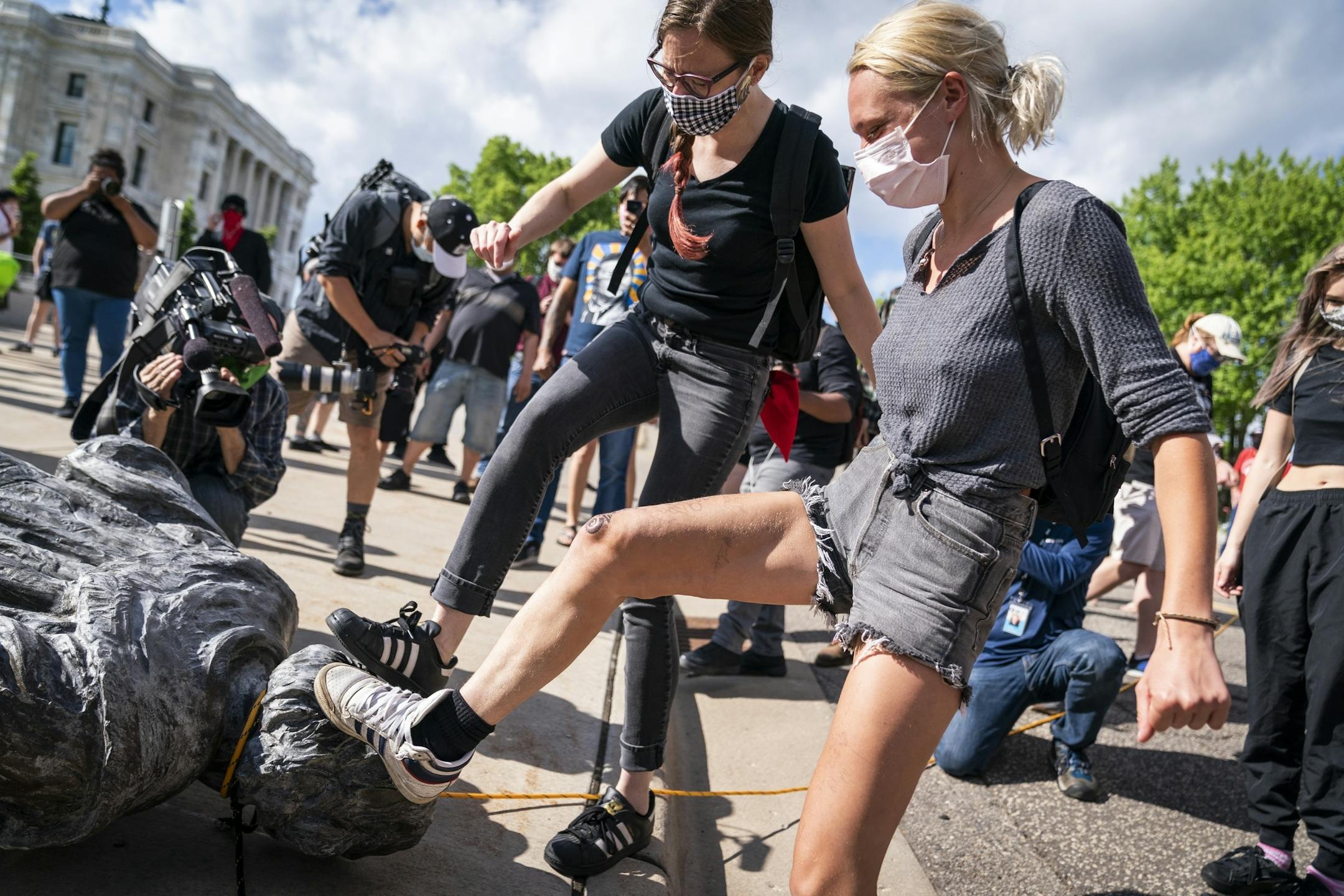 People took turns kicking the Christopher Columbus statue after it was toppled.