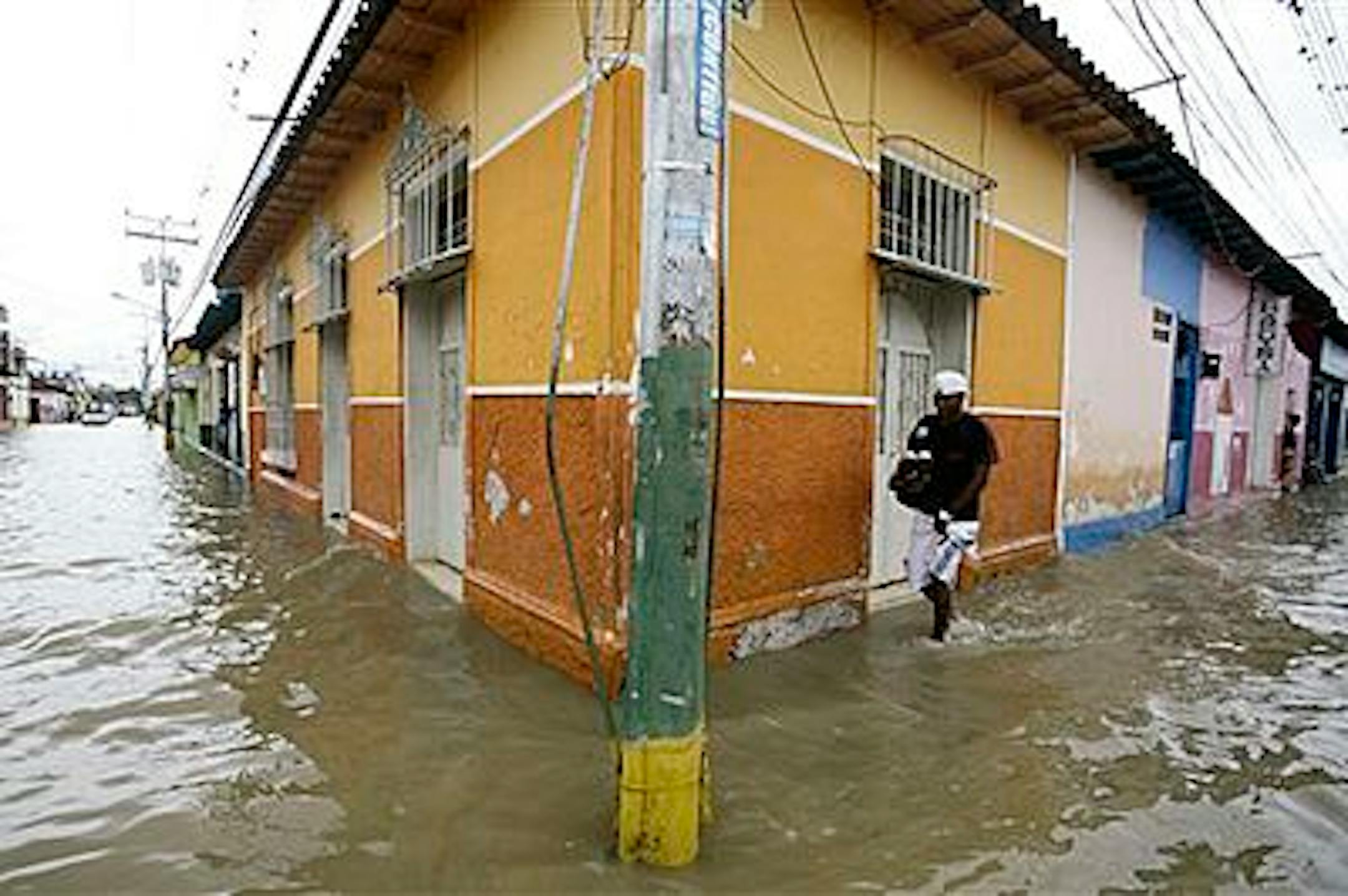 A man wades through a flooded street in Rio Chico, central Venezuela, Saturday, Dec. 4, 2010. According to Venezuelan authorities, flooding and landslides unleashed by the rains over the last two weeks have killed at least 32 people, forced more than 5,000 from their homes, and over 60,000 people living in high-risk areas have been brought to hundreds of shelters. (AP Photo/Cecilia Serrano)