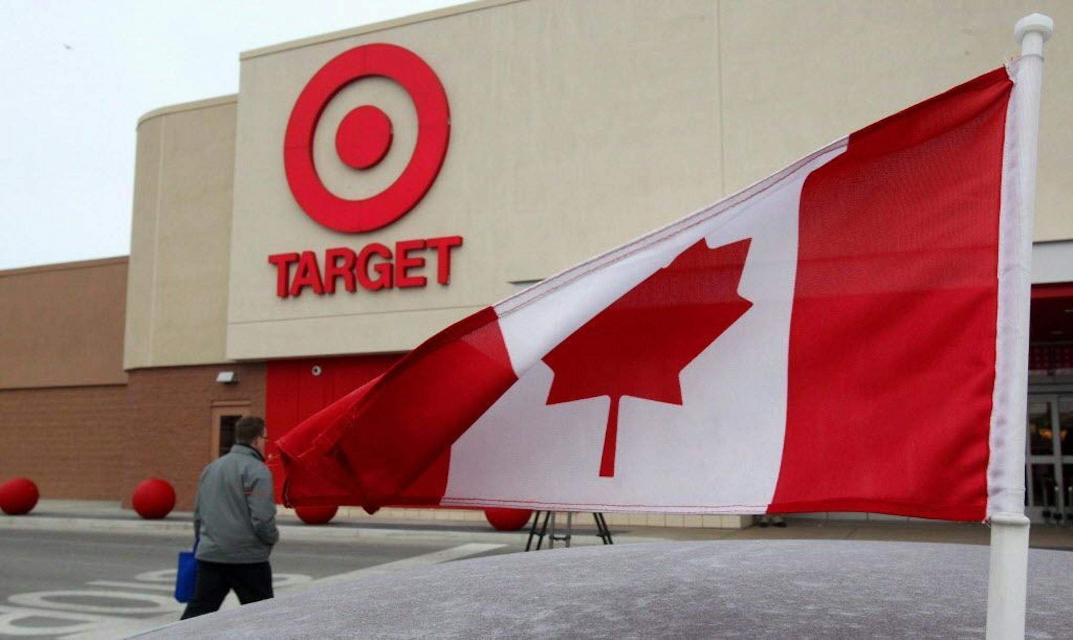 In this March 5, 2013 photo, a Canadian flag flies on the car of a customer's car parked in front of a Target store in Guelph, Ontario.