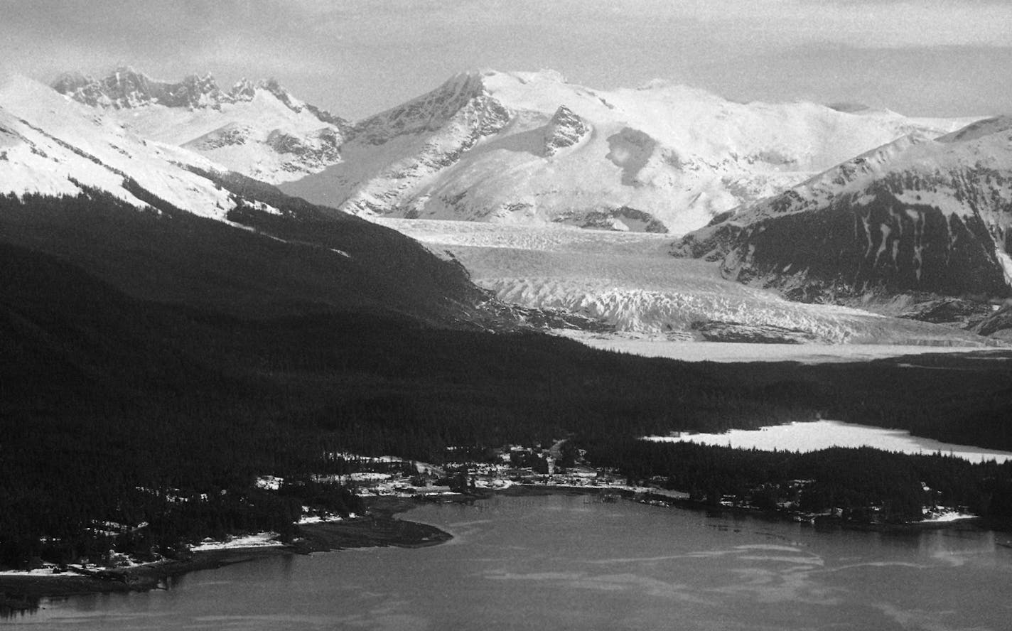 In this Juneau subdivision, seen May 31, 1974, everyone has a glacier for a neighbor. The Mendenhall Glacier, background, looks forboding but Alaska experts say the giant sheet of ice is nearly stagnant. (AP Photo/George Brich)