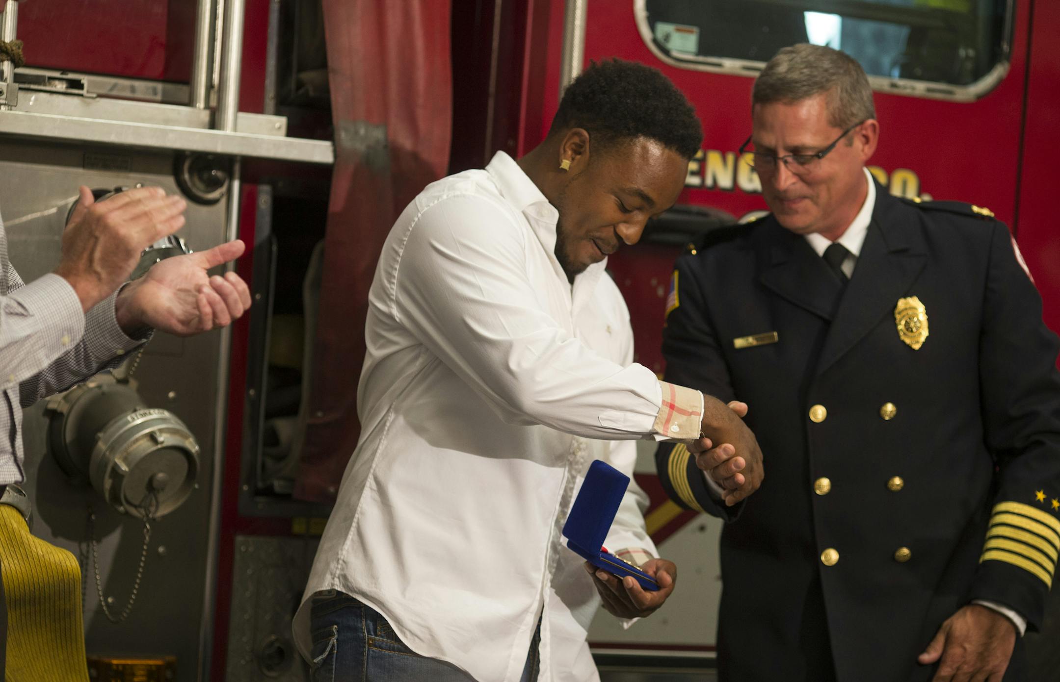 St. Paul Fire Chief Tim Butler, right, handed Donnell Gibson the department’s Meritorious Service Award on Tuesday at Fire Station 22.