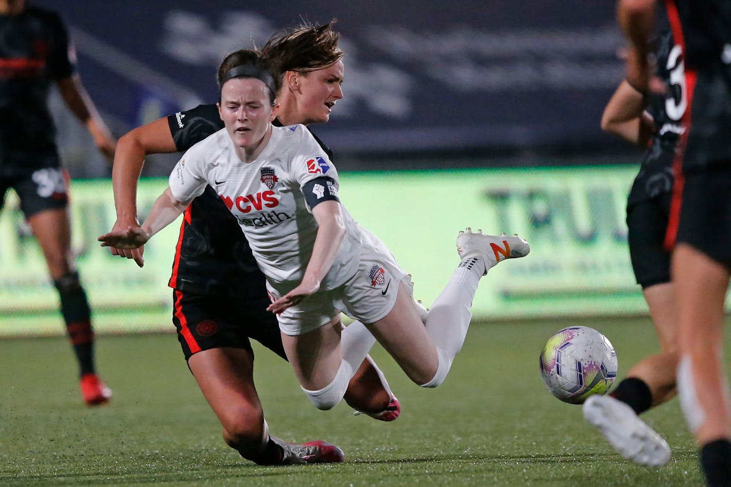 Washington Spirit midfielder Rose Lavelle is tackled by Portland Thorns midfielder Lindsey Horan in an NWSL Challenge Cup match on July 5 at Zions Bank Stadium in Herriman, Utah.