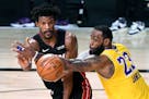 ORLANDO, FLORIDA OCTOBER 6, 2020-Lakers LeBron James tries to break up a pass from Heat's Jimmy Butler in the 4th quarter in Game 4 of the NBA FInals 