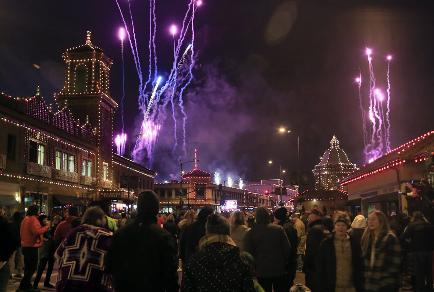 A crowd watches building lights come on as fireworks light up the sky during the Plaza Lighting Ceremony in Kansas City, Mo., Thursday, Nov. 28, 2019. The Country Club Plaza is a famous shopping district in Kansas City. This is the 90th year of the Plaza lights. (AP Photo/Orlin Wagner)