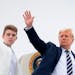 U.S. President Donald Trump and his son Barron wave as they board Air Force One at Morristown Municipal Airport in Morristown, New Jersey, on Aug. 16,