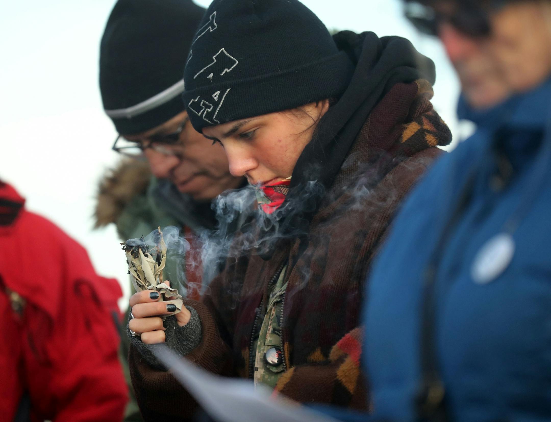 Reed Two Bulls of South Minneapolis burns sage Tuesday, Oct. 29, 2019, in St. Paul, MN. Clergy and protestors gathered for a service and communion outside the Whipple Federal Building and to protest the naming of the building after the Episcopal bishop because deportations and other actions at the courthouse are in opposition to the beliefs of the Episcopal church, they stated.