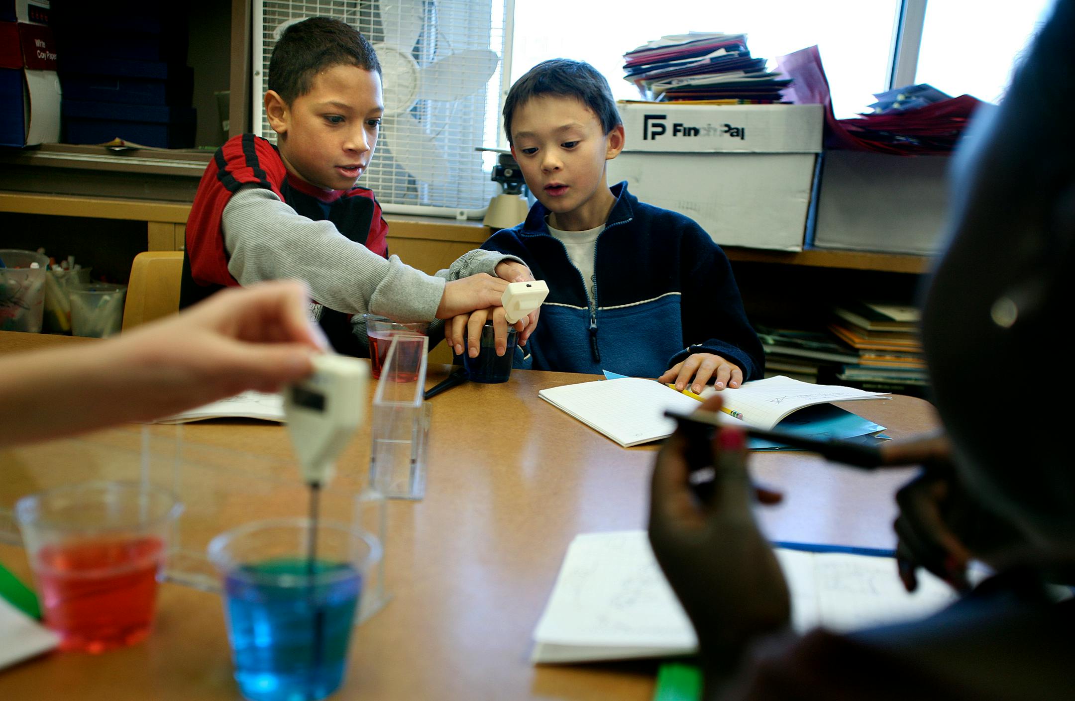 In fourth-grade science teacher Jim Schrankler's class at St. Anthony Park Elementary School, Freddy Reeves, left, and Jackson Muehlbauer took part in a water density experiment. They used vials of red and blue water at different temperatures and mixed them to measure the results.