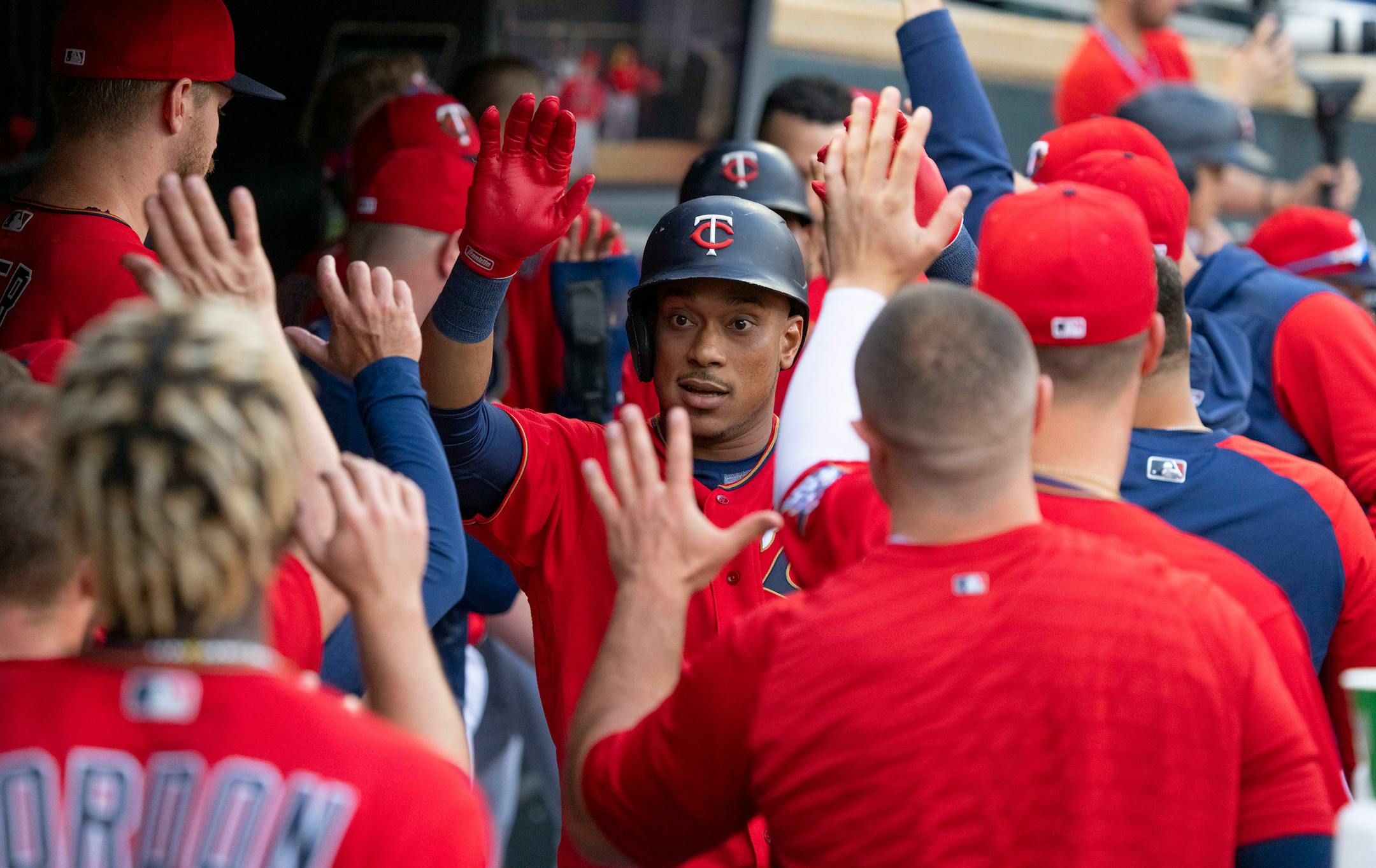 Minnesota Twins second baseman Jorge Polanco (11) high fives teammates in the dugout after hitting a home run in the first inning.