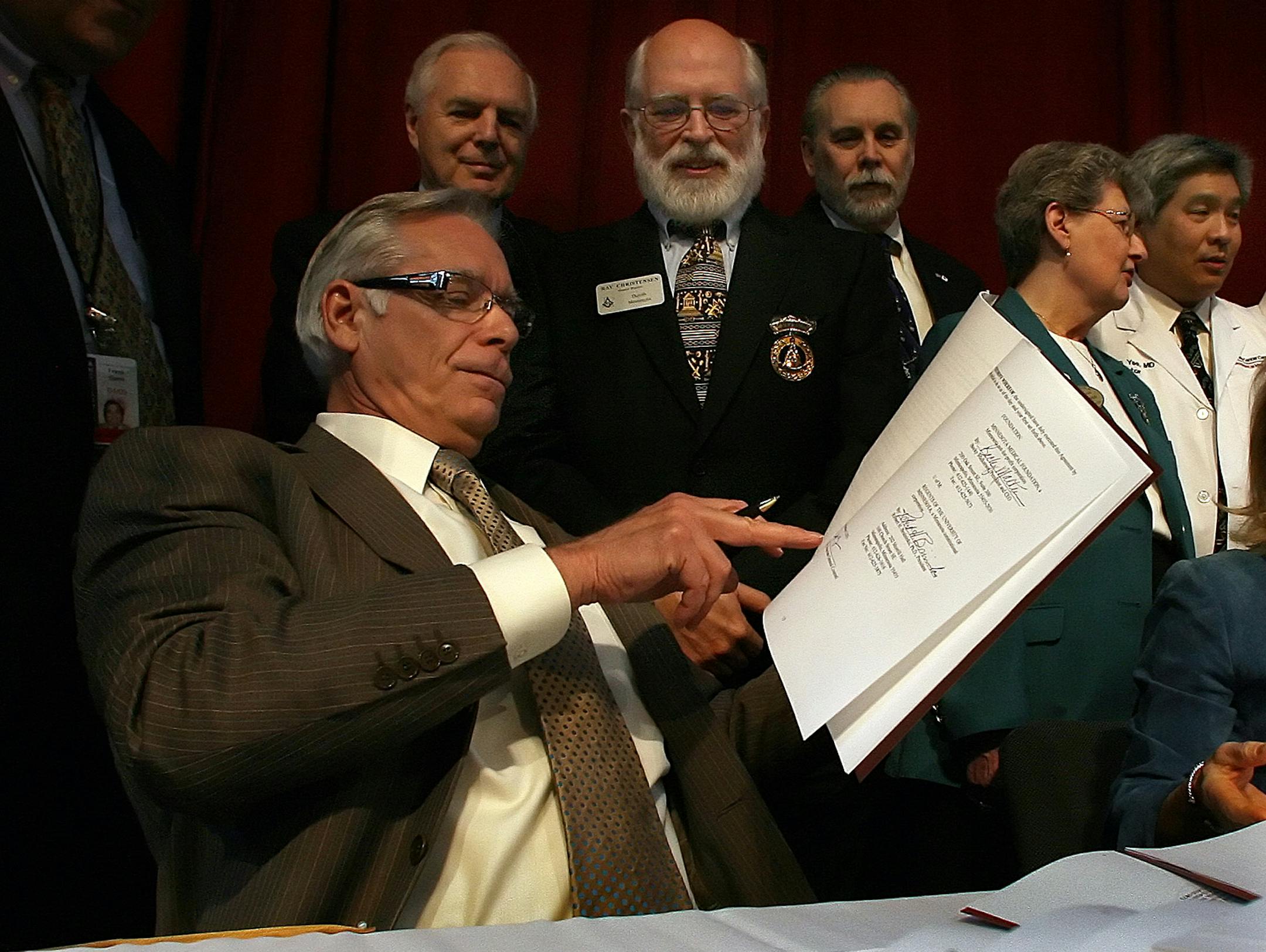 University of Minnesota President Robert Bruininks, foreground, helped announce the $65 million gift to cancer research and care, the U's largest gift ever.