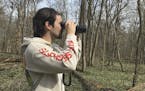 In this March 24, 2020 photo, provided by Conner Brown, he is seen using binoculars to look for birds in Cedar Island, Maryland. Brown, a 25-year-old 
