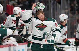 Minnesota Wild goaltender Filip Gustavsson puts on his mask after a quick repair in the first period of an NHL preseason hockey game against the Color