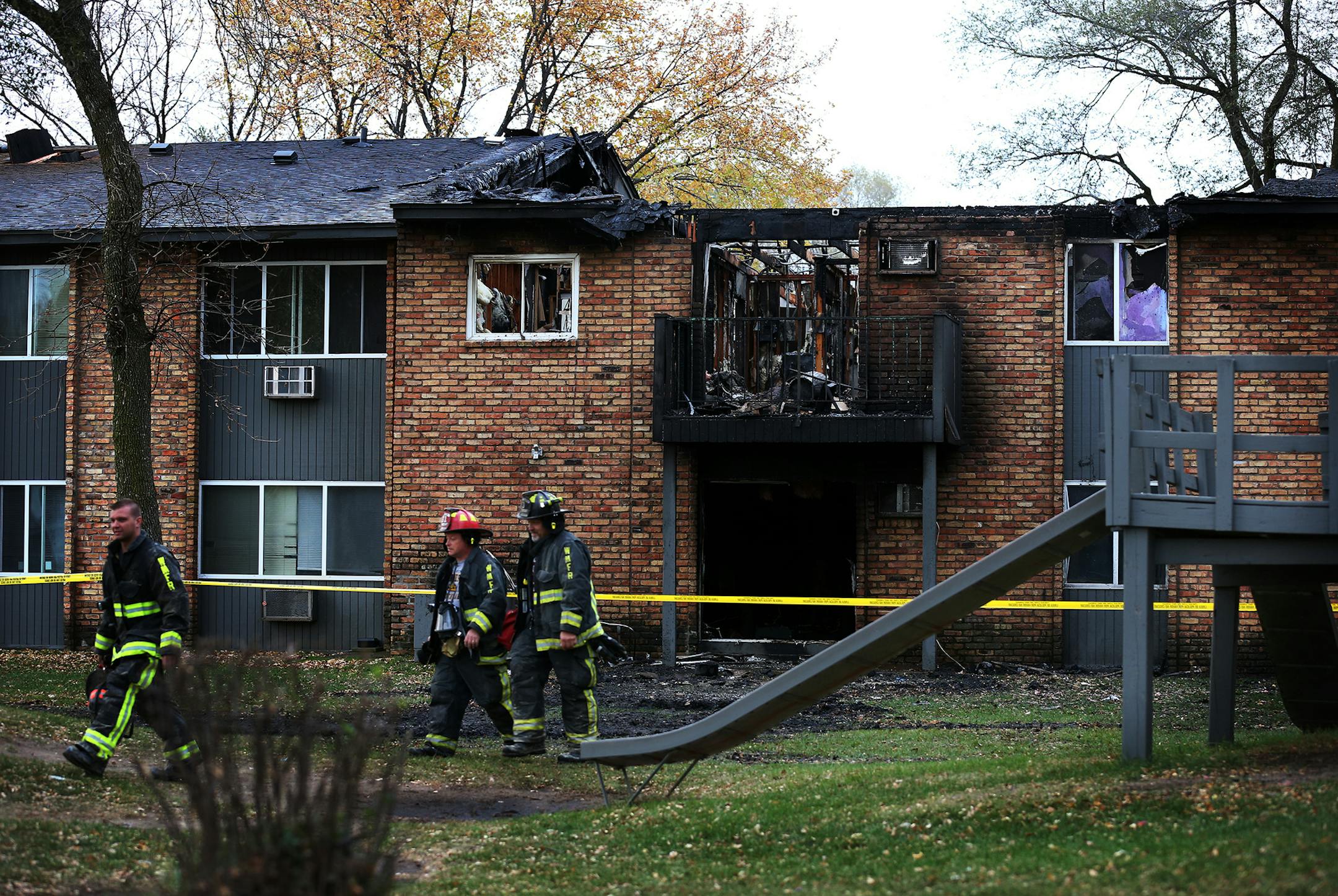 Brooklyn Center firefighters walk outside a charred Brooklyn Center apartment building inside which a late evening fire started Sunday, was seemingly under control at one point only to start up again many hours later early Monday, November 3. The flames were first detected between 6 and 6:30 p.m. Sunday in a lower unit of the building at 604 69th Avenue N. and again around 4 a.m. on Monday morning. There were no injuries. ] LEILA NAVIDI leila.navidi@startribune.com /