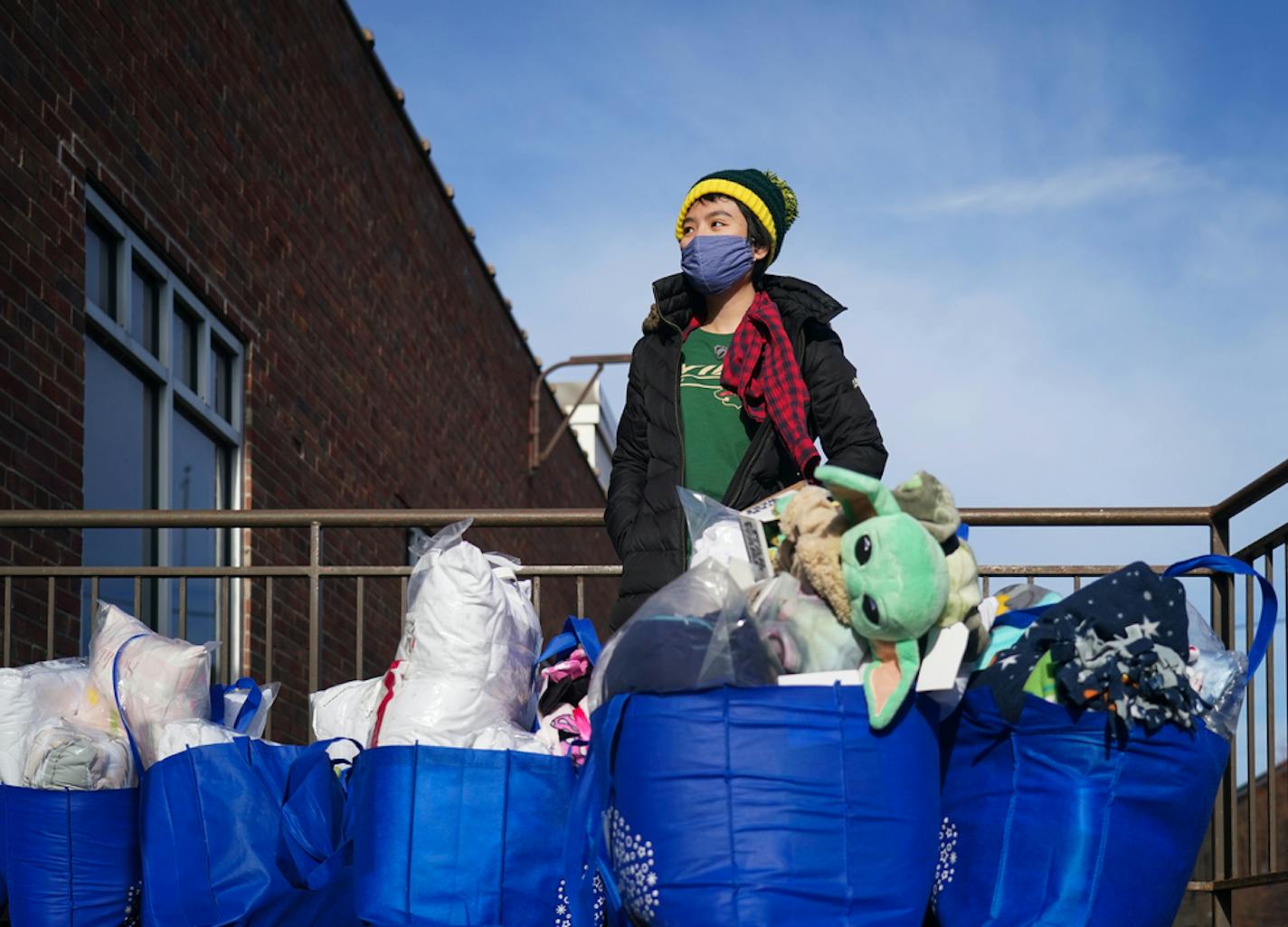 Volunteer Jenny Thai stood on a loading dock with the multiple bags of sheets, blankets, books and toys which were delivered to childen through My Very Own Bed in northeast Minneapolis.