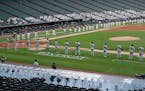 The Chicago White Sox, top, and Minnesota Twins hold a black ribbon for social justice before the season opener Friday