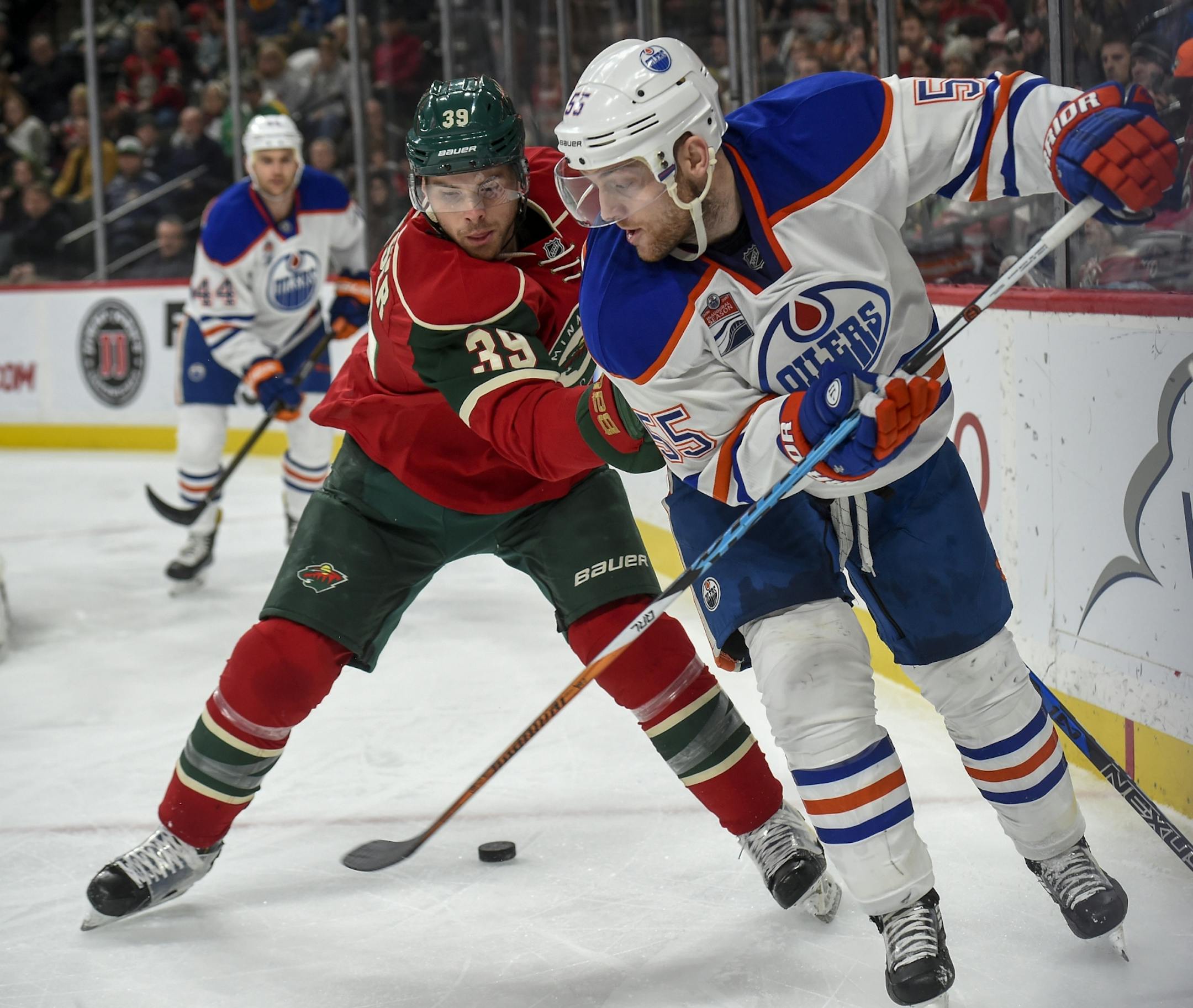 Edmonton Oilers' center Mark Letestu, right, passes the puck back and through the legs of Minnesota Wild defenseman Nate Prosser (39) during the second period of an NHL hockey game, Friday, Dec. 9, 2016, in St. Paul, Minn.