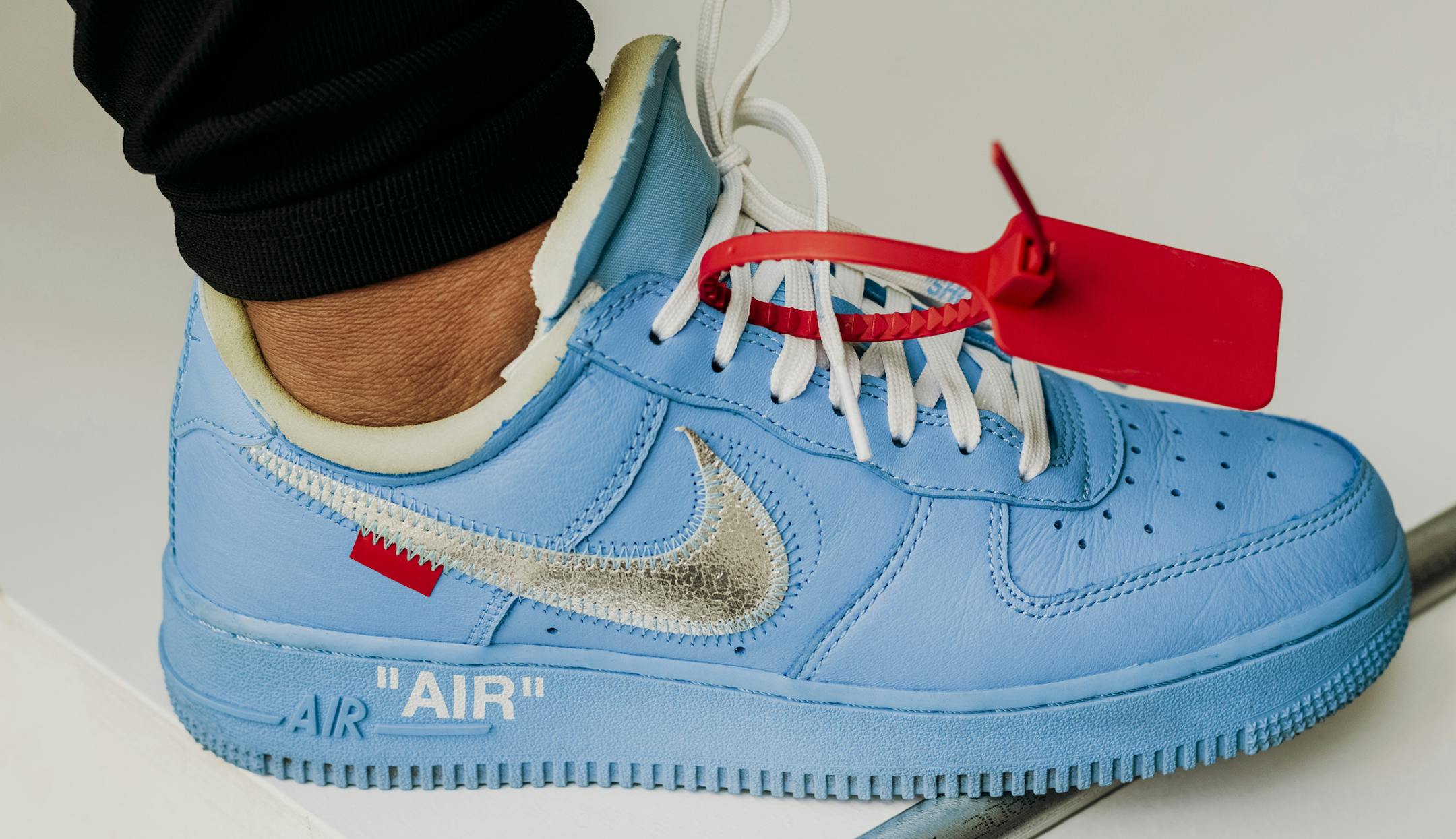 A limited-edition cool-blue Nike Air Force 1, designed for the Virgil Abloh exhibition, "Figures of Speech," is worn by a security guard at the Museum of Contemporary Art Chicago, Aug. 12, 2019. The exhibition tries to capture the essence of the prodigious fashion designer — an endeavor with radical juxtapositions, clever products and some missed opportunities. (Whitten Sabbatini/The New York Times)