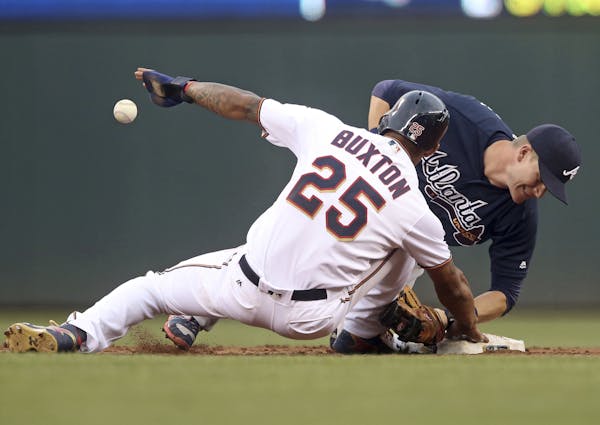 Atlanta Braves second baseman Gordon Beckham right, loses the ball as he attempts to tag Minnesota Twins' Byron Buxton off the base as Buxton returned