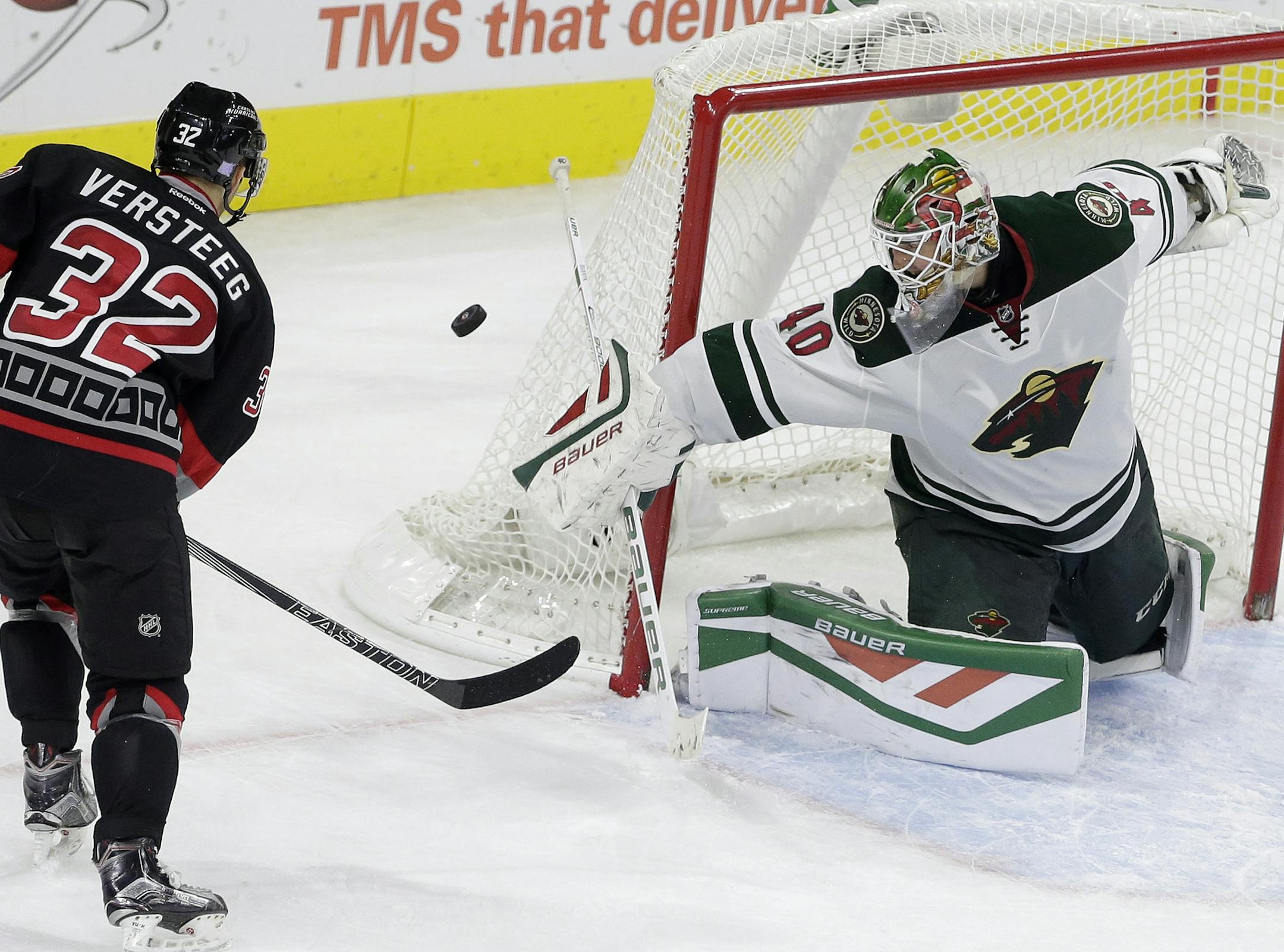 Carolina Hurricanes' Kris Versteeg (32) has a shot on goal deflected by Minnesota Wild goalie Devan Dubnyk (40) during overtime of an NHL hockey game in Raleigh, N.C., Thursday, Nov. 12, 2015. Minnesota won 3-2. (AP Photo/Gerry Broome)
