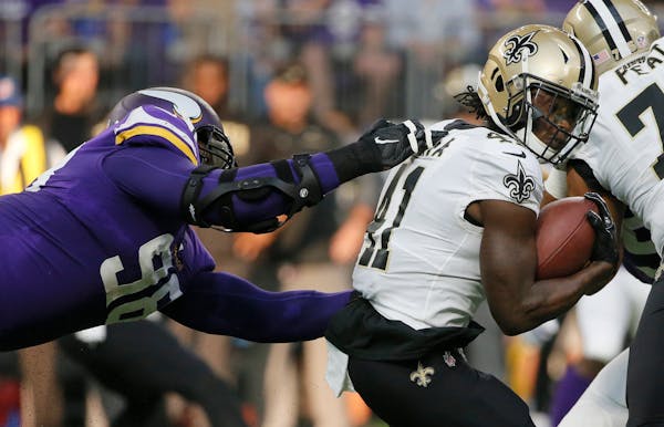 Saints running back Alvin Kamara, right, tried to elude the grasp of Vikings defensive end Brian Robison during the first half Sept. 11. Now the Saint