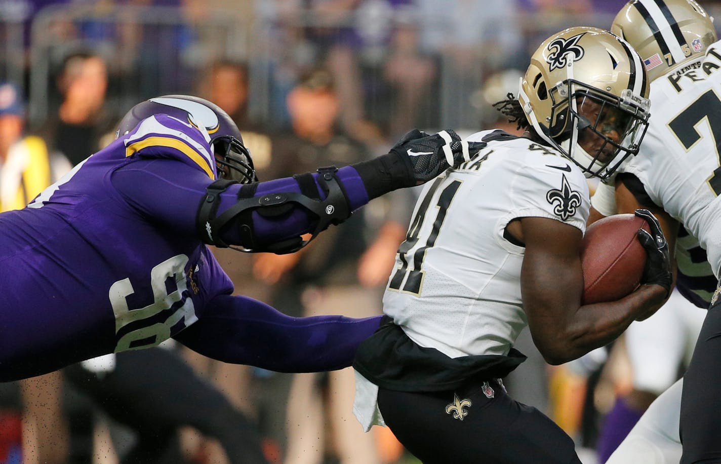 Saints running back Alvin Kamara, right, tried to elude the grasp of Vikings defensive end Brian Robison during the first half Sept. 11. Now the Saints and Vikings will meet again in the NFC playoffs.