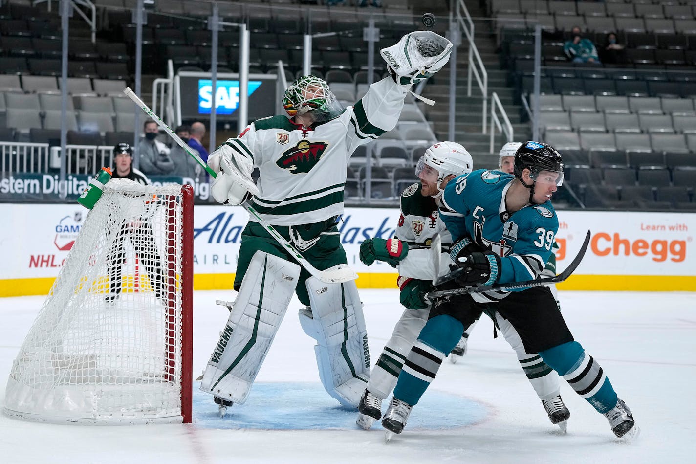 Minnesota Wild goaltender Kaapo Kahkonen (34) catches the puck next to San Jose Sharks center Logan Couture (39) during the third period of an NHL hockey game Saturday, April 24, 2021, in San Jose, Calif. (AP Photo/Tony Avelar)