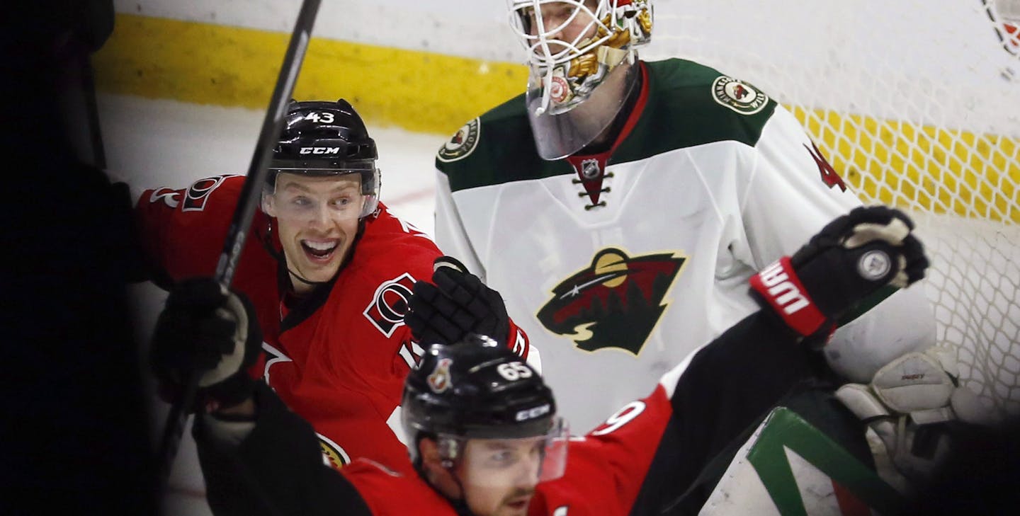 Minnesota Wild goaltender Devan Dubnyk (40) reacts as Ottawa Senators' Erik Karlsson (65) celebrates his overtime goal, in front of teammate Ryan Dzingel (43) during an NHL hockey game Tuesday, March 15, 2016, in Ottawa, Ontario. (Fred Chartrand/The Canadian Press via AP)