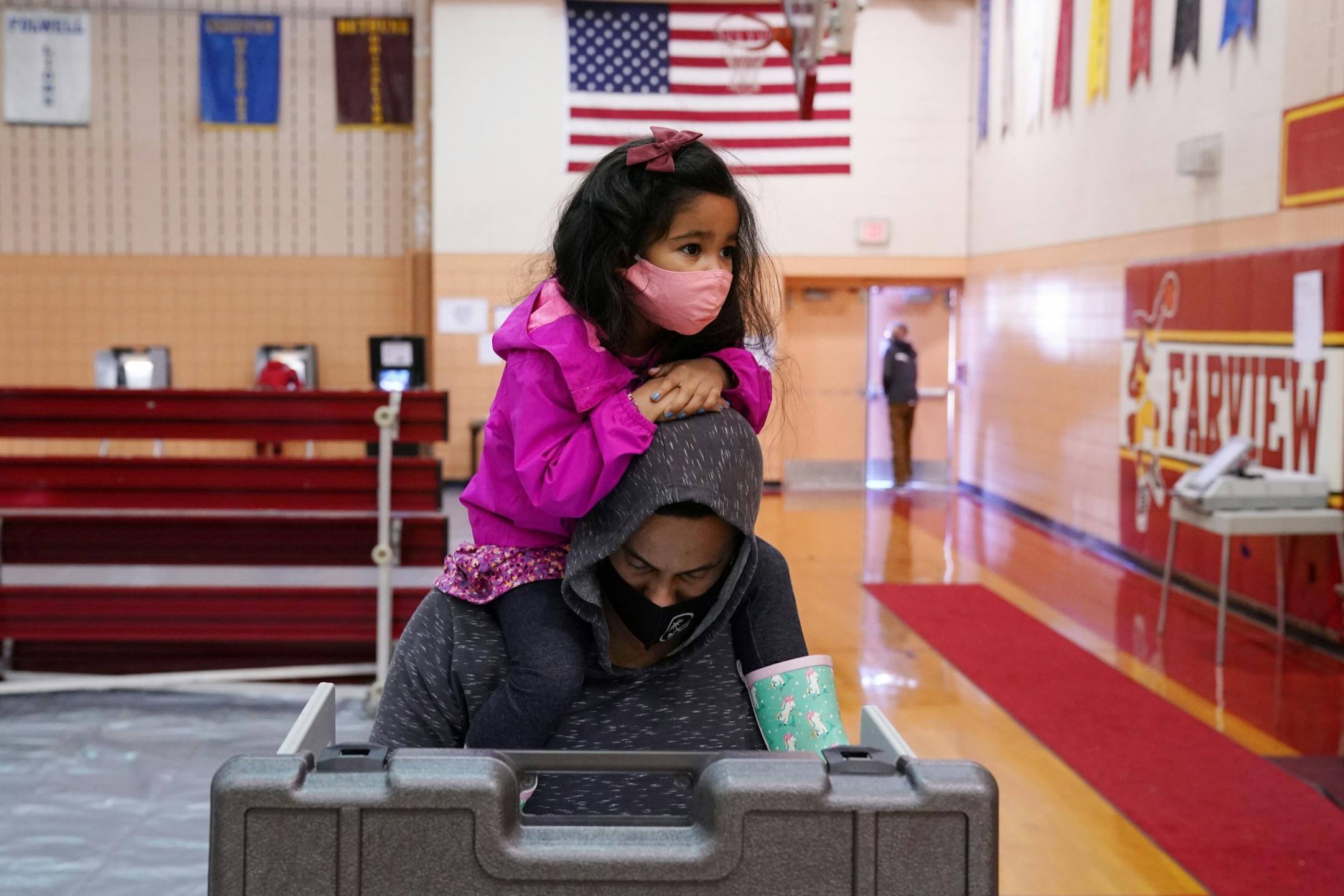 Timothy Mulari votes with his daughter on his shoulders as he voted at the Farview Park Recreation Center in north Minneapolis on Election Day.