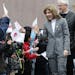 New U.S. Ambassador to Japan Caroline Kennedy, accompanied by her husband Edwin Schlossberg, smiles and waves at schoolchildren greeted her with the U