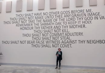 Grand Rapids resident Dana Butler beneath the Ten Commandments that were painted on the wall of the new Itasca County jail until recently.