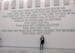 Grand Rapids resident Dana Butler beneath the Ten Commandments that were painted on the wall of the new Itasca County jail until recently.